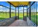 Covered patio with wrought iron gate opens to a sprawling green pasture at 13832 Bay Lake Rd, Groveland, FL 34736