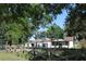 A charming house with a gated entrance and large yard, viewed from the side at 13832 Bay Lake Rd, Groveland, FL 34736
