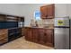 Small galley kitchen with dark wood cabinets, granite countertops, and stainless steel appliances at 13832 Bay Lake Rd, Groveland, FL 34736