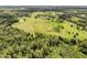 Wide shot of property with home, pond, and large pasture at 13832 Bay Lake Rd, Groveland, FL 34736