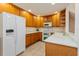 Kitchen with light wood cabinets, white appliances, and ample counter space at 123 Carrick Bend Way, Clermont, FL 34711