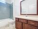 Bathroom with dark wood vanity, a shower/tub combo and tile at 17106 Gathering Place Cir, Clermont, FL 34711