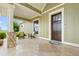 Inviting front porch with stone details and comfortable seating, overlooking a scenic view at 2499 Nw 102Nd Blvd, Wildwood, FL 34785