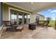 Relaxing covered patio with fire pit and wicker furniture, overlooking scenic landscape at 2499 Nw 102Nd Blvd, Wildwood, FL 34785