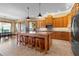 Gourmet kitchen featuring wood cabinetry, granite island, and stainless steel appliances at 2499 Nw 102Nd Blvd, Wildwood, FL 34785