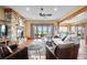 Spacious living room with stone fireplace, hardwood floors, and access to a patio overlooking the golf course at 2499 Nw 102Nd Blvd, Wildwood, FL 34785