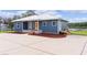 Blue house with a metal roof and a spacious driveway at 4114 Dove Valley Ln, Lady Lake, FL 32159