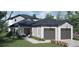Two-story home with gray siding, two-car garage, and landscaping at 576 Casey Loop, Mount Dora, FL 32757