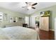 Main bedroom with hardwood floors, and french doors leading to lanai at 7151 Se 173Rd Arlington Loop, The Villages, FL 32162