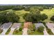 Aerial view of a house and surrounding area, with a pond and open field at 7151 Se 173Rd Arlington Loop, The Villages, FL 32162