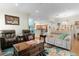 Open concept living room with hardwood floors, comfortable seating, and views to kitchen at 7151 Se 173Rd Arlington Loop, The Villages, FL 32162