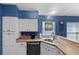 Modern kitchen with wood countertops, stainless steel sink, and white cabinets at 1914 Iglesia St, The Villages, FL 32159