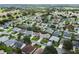 Aerial perspective of a large residential area featuring numerous houses, tree-lined streets, and open green spaces at 1914 Iglesia St, The Villages, FL 32159