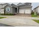 Two-story house with gray siding, white garage doors, and landscaping at 2396 Juniper Berry Dr, Minneola, FL 34715