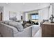 Bright living room with gray sectional sofa and sliding glass doors at 2396 Juniper Berry Dr, Minneola, FL 34715