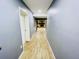 Basement hallway with light wood-look flooring and gray walls leading to a fireplace at 1817 Demastus Ln, Ocoee, FL 34761