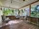 Wooden porch with metal furniture and view of trees at 853 Cr 484, Lake Panasoffkee, FL 33538