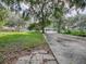 Large backyard with a grassy area and a paved driveway at 853 Cr 484, Lake Panasoffkee, FL 33538