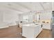 Modern white kitchen with island, stainless steel appliances, and hardwood floors at 137 S Park Ave, Winter Garden, FL 34787