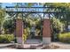 Ornate metal arch entry to Centennial Plaza with brick columns and purple flowers at 137 S Park Ave, Winter Garden, FL 34787