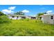 Overgrown backyard with tall grass and two sheds at 1620 Morin St, Eustis, FL 32726