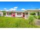 One-story house with red door and carport at 1620 Morin St, Eustis, FL 32726