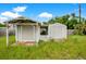 Two storage sheds in the overgrown backyard at 1620 Morin St, Eustis, FL 32726