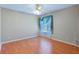 Bedroom with wood flooring, window, and ceiling fan at 21127 Lady Marion Way, Leesburg, FL 34748