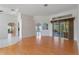 Spacious living room featuring hardwood floors, a sliding glass door, and arched doorways at 21127 Lady Marion Way, Leesburg, FL 34748