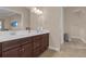 Double vanity bathroom with dark brown cabinets and a large mirror at 7616 Lily Ct, Groveland, FL 34736