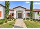 Front entrance of Mediterranean style home with landscaping at 7616 Lily Ct, Groveland, FL 34736