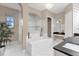 Spa-like bathroom featuring a soaking tub, dual vanities, and designer tile at 7616 Lily Ct, Groveland, FL 34736