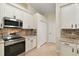 Bright kitchen, granite countertops, stainless steel appliances, and white cabinets at 114 Compass Rose Dr, Groveland, FL 34736
