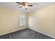 Bright bedroom with ceiling fan, window shutters, and grey carpeting at 114 Compass Rose Dr, Groveland, FL 34736