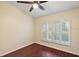 Bedroom with wood-look tile floors and a large window with shutters at 114 Compass Rose Dr, Groveland, FL 34736