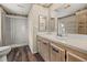 Bathroom with shower, vanity, and wood-look flooring at 1209 Apache Cir, Tavares, FL 32778