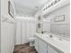 Well-lit bathroom with shower, vanity, and white cabinets at 533 Grand Vista Trl, Leesburg, FL 34748