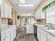 Open kitchen with white cabinets, stainless steel appliances, and a view to the dining area at 533 Grand Vista Trl, Leesburg, FL 34748