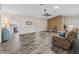 Living room showcasing wood-look floors and access to kitchen at 533 Grand Vista Trl, Leesburg, FL 34748