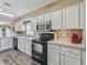Modern kitchen featuring stainless steel appliances and white cabinets at 533 Grand Vista Trl, Leesburg, FL 34748