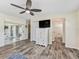 Spacious bedroom with hardwood floors, ceiling fan, dresser, and private bathroom access at 533 Grand Vista Trl, Leesburg, FL 34748