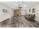 Open living room with wood-look floors and a brown accent wall at 533 Grand Vista Trl, Leesburg, FL 34748