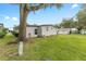 Side view of a mobile home with large tree at 512 Palo Verde Dr, Leesburg, FL 34748
