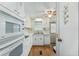 White kitchen features ample cabinetry and wood flooring at 512 Palo Verde Dr, Leesburg, FL 34748