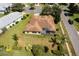 Single-Gathering home with screened lanai, brown roof, and a well-manicured lawn at 27303 Gingerbread Pl, Leesburg, FL 34748