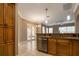 Kitchen with granite countertops, stainless steel dishwasher, and wood cabinets at 27303 Gingerbread Pl, Leesburg, FL 34748