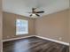 Bright bedroom with hardwood floors, a ceiling fan, and a large window at 27303 Gingerbread Pl, Leesburg, FL 34748