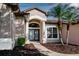 Front entry with double doors and landscaping at 27303 Gingerbread Pl, Leesburg, FL 34748