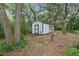 White storage shed with black trim, ramp, and lush green surroundings at 1136 Brick Rd, Winter Garden, FL 34787