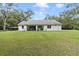 White house exterior with covered patio, green lawn, and large backyard at 1136 Brick Rd, Winter Garden, FL 34787